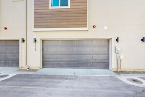 A residential garage with two doors, a window above the garage, and a utility box on the right side. - Modern Townhouse, Centrally Located Near BSU (Boise)