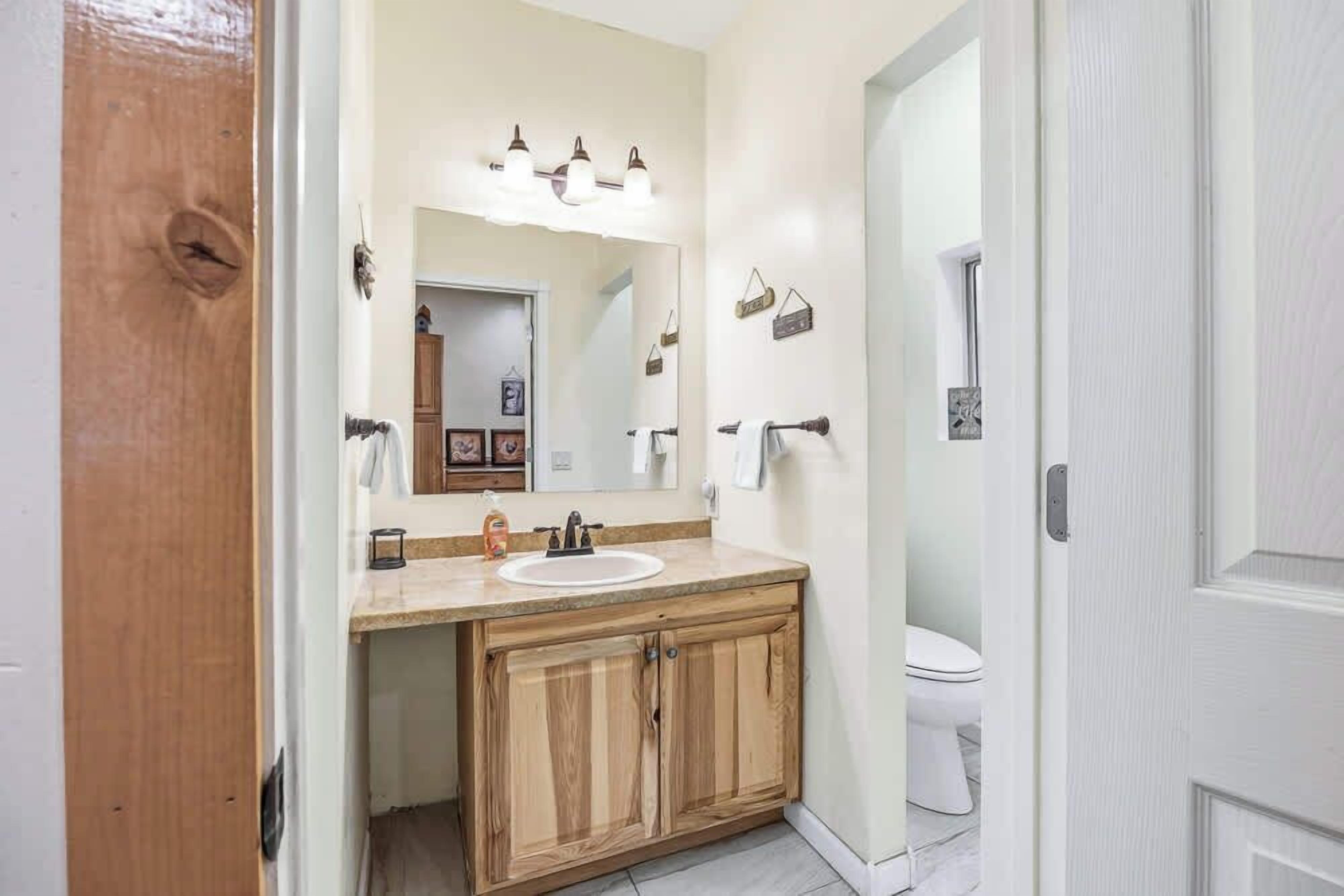 Een badkamer met een houten wastafelmeubel, een wastafel en een toilet.