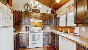 A kitchen with wooden cabinets, a stove, a dishwasher, and a sink. - Cascade Cabin | Deck, 2 Living Rooms + Fireplaces (Cascade)