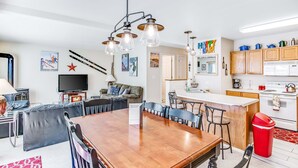 Eine moderne Küche mit Holzausstattung, einer weißen Arbeitsplatte und einer roten Mülltonne.