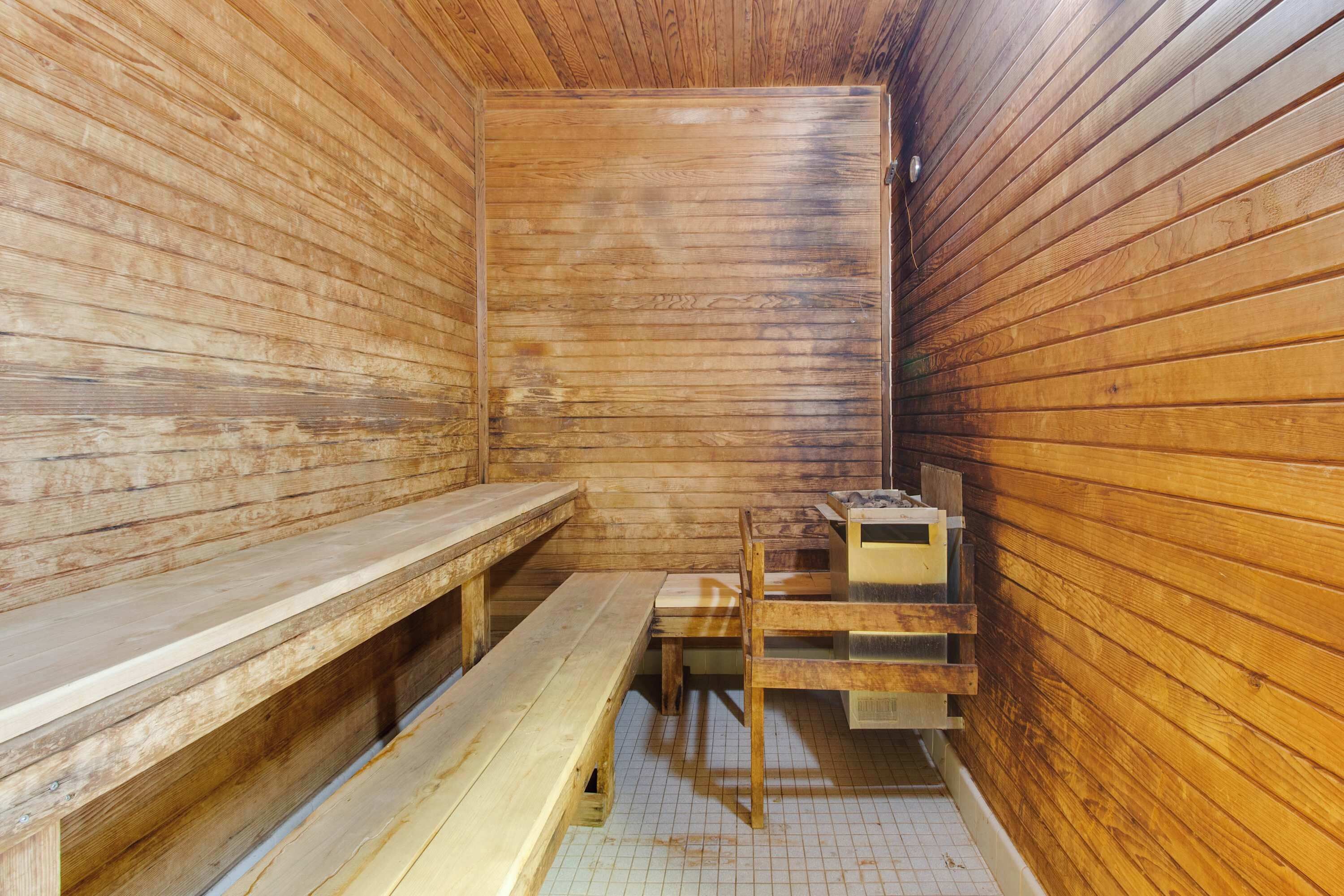 Una sala de sauna con bancos de madera y una mesa.