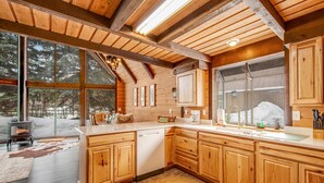 Una cocina amplia con armarios de madera, un ventanal grande y una estufa empotrada.