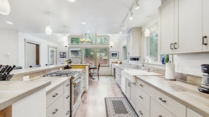 A modern kitchen with a central island, ample counter space, and large windows providing natural light.