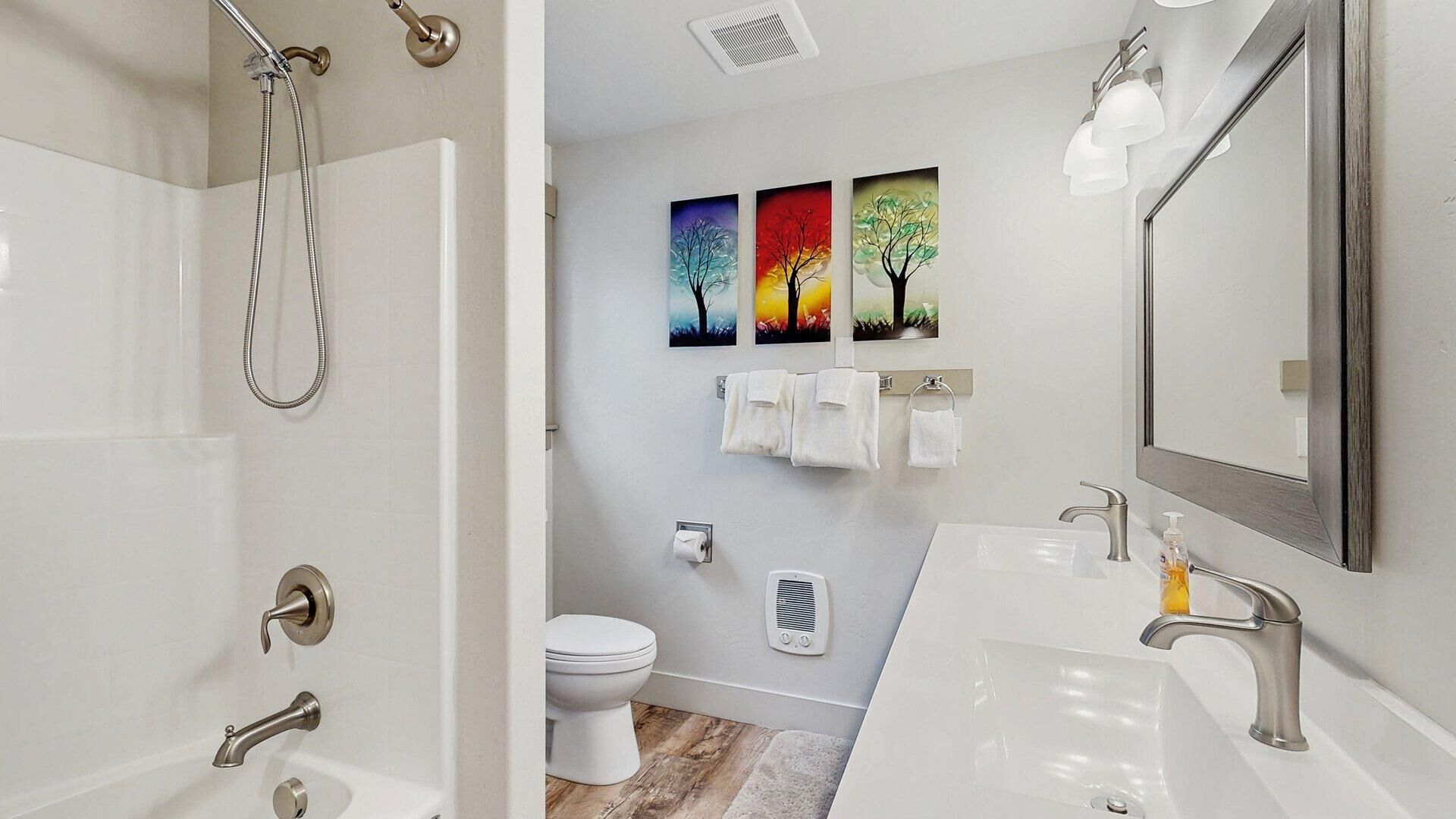 Ein modernes Badezimmer mit Dusche, Toilette, Waschbecken und Spiegel.