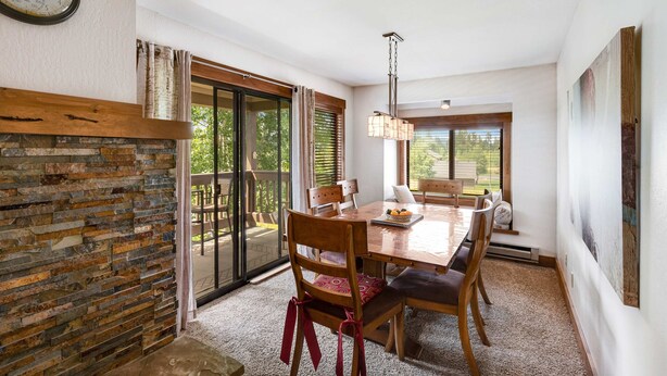 A dining area with a wooden table, chairs, and a chandelier. - McCall Condo | Walk to Lake, Shops & Parks (McCall)