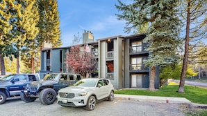 A modern multi-story building with a garage parking area. - Downtown McCall Condo | Fireplace + Balcony (McCall)