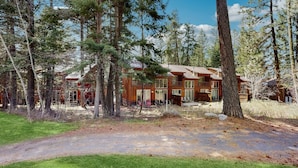 A cabin with a deck, surrounded by tall trees and a clear sky. - Golf Course Retreat | Patio & Near Downtown McCall (McCall)
