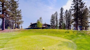 A golf course with a clubhouse in the background. - Mountain View Retreat | Pool & Golf Access (New Meadows)