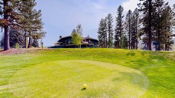 A golf course with a clubhouse in the background.