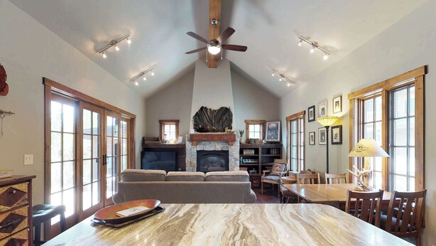 Amplia sala de estar con chimenea, una isla grande de mármol y una mesa de comedor con sillas.
