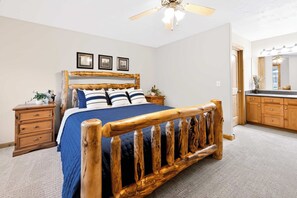 A bedroom with a wooden bed, a nightstand, a dresser, and a ceiling fan. - McCall 3 Bedroom Condo | Walk to Lake, Park & Golf (McCall)