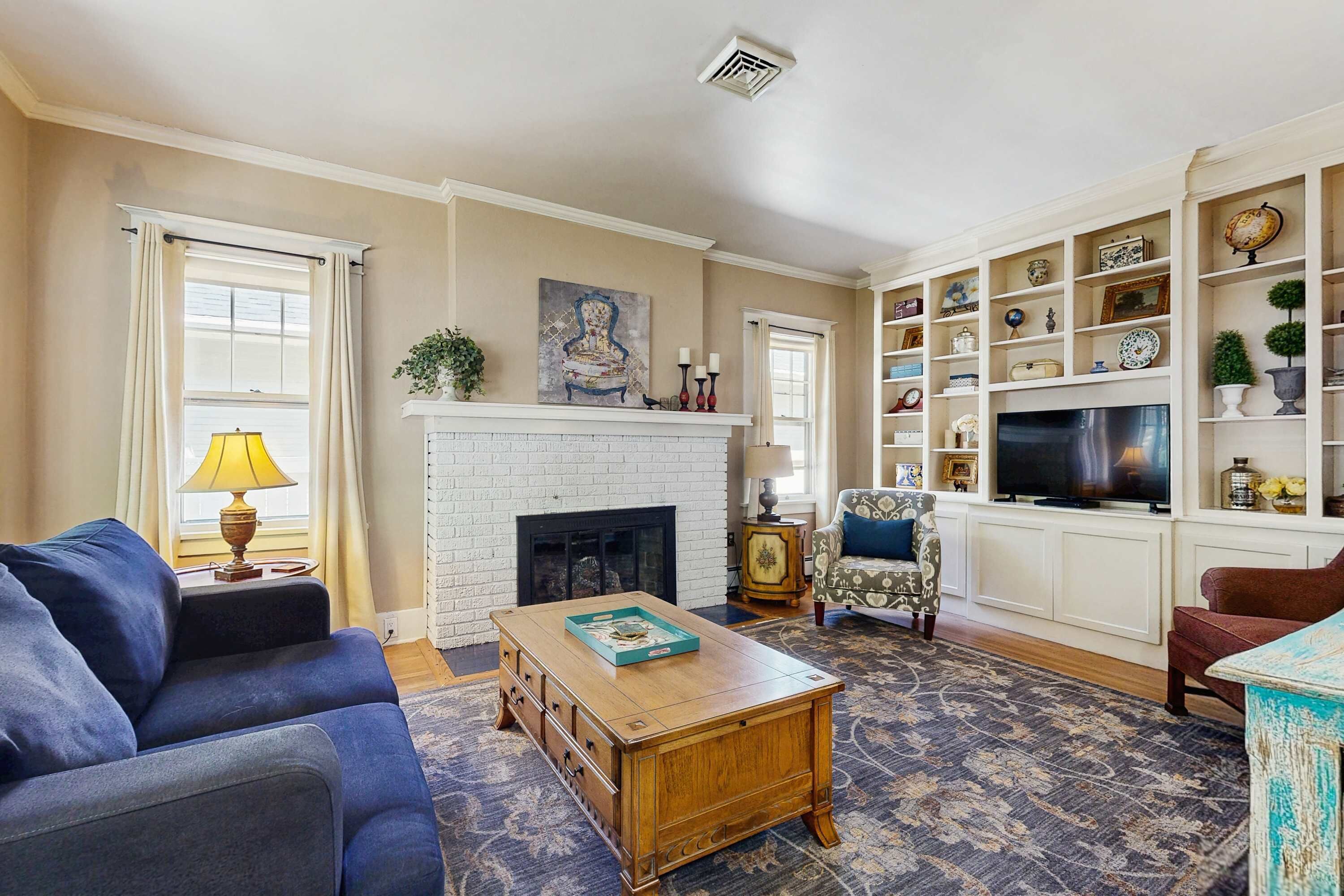 A living room with a fireplace, a sofa, a coffee table, and a television.