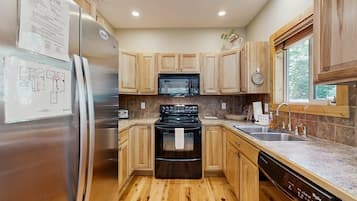 A modern kitchen with wooden cabinets, stainless steel appliances, a microwave, oven, and dishwasher.