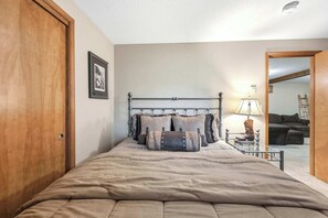 A bedroom with a bed, a bedside table, a lamp, and a mirror.