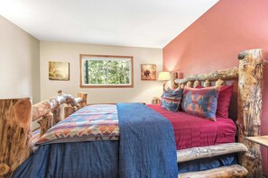 A bedroom with a bed, a window, and wooden decor.