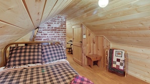 A cozy room with a bed, a wooden desk, and a small bench.