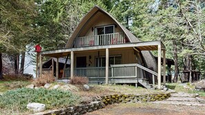 A two-story cabin with a balcony, surrounded by trees. - Cozy A-Frame Cabin in Downtown McCall (McCall)