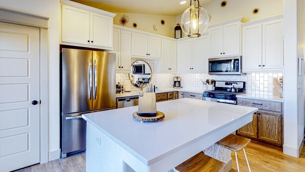 A modern kitchen with white cabinets, stainless steel appliances, and a central island. - Spacious Meridian Retreat Near Parks & Golf (Meridian)