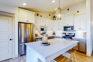 A modern kitchen with white cabinets, stainless steel appliances, and a central island. - Spacious Meridian Retreat Near Parks & Golf (Meridian)