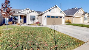A suburban house with a garage, a front porch, and a well-maintained lawn. - Spacious Meridian Retreat Near Parks & Golf (Meridian)