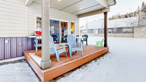 A covered porch with wooden flooring and a concrete column, surrounded by snow. - Modern McCall Family Retreat, Loft, AC, Deck (McCall)
