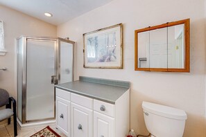 Une salle de bain avec une douche, des toilettes et un lavabo avec un miroir.