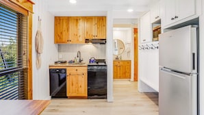 A modern kitchen with wooden cabinets, a stainless steel refrigerator, and a dishwasher.
