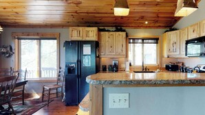 A kitchen with wooden cabinets, granite countertops, and a built-in island. - New Meadows Cabin Game Room, Pool & Deck (New Meadows)