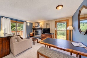 A cozy living room with a fireplace, television, and a dining area. - Bogus Basin Ski-In/Ski-Out Condo, Two Decks (Boise)