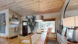 Ein Essbereich aus Holz mit Tisch, Stühlen und einer Hängelampe.