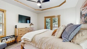 Una camera da letto con un letto, una cassettiera, una TV e una finestra.