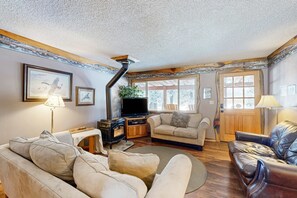 Una sala de estar acogedora con chimenea, asientos cómodos y ventanas amplias.