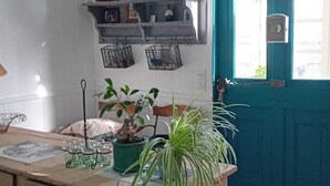 Une cuisine avec un comptoir en bois, une porte bleue et un sol à carreaux.