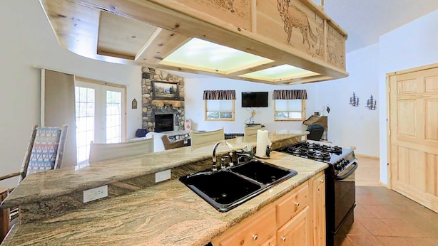 A kitchen with a granite countertop, double sink, and a stove. - McCall Golf Home | Patio, Fenced Yard & Views (McCall)