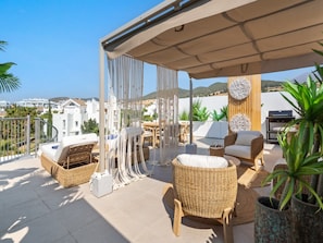 A rooftop terrace with wicker furniture, a table, and a grill. - Estepona Garden Apartment for 3 (Casares)