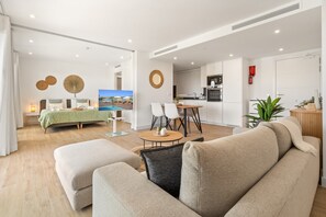 Ein modernes Wohnzimmer mit einer Couch, einem Essbereich und einer Küche.