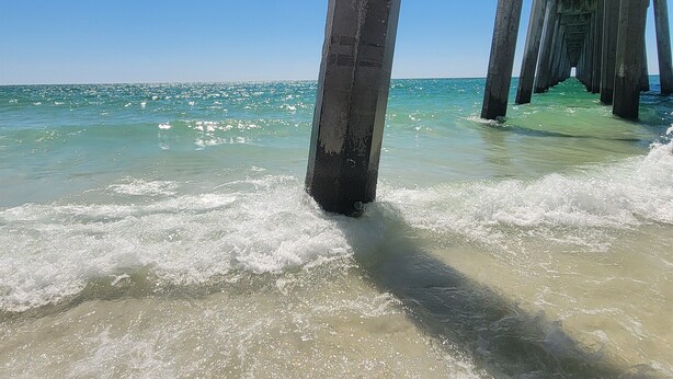 A pier extending into calm waters with clear skies. - Sand Dollar 6mi-Pensacola Bch (Gulf Breeze)