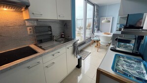 Una cocina moderna con armarios blancos, horno empotrado y un amplio ventanal con vistas al exterior.
