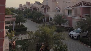 A residential area with multiple houses, a paved pathway, and a white car parked on the street.