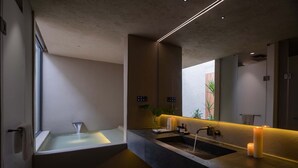 Un baño moderno con una bañera grande, un tocador doble y un espejo amplio.