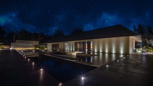 Un edificio moderno con piscina e iluminación exterior.