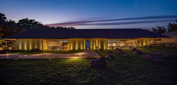 A modern house with a large open patio, a dining area, and a well-lit entrance. - Weizhou Island Coral Reef Hotel (Beihai)