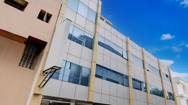 A modern building with a flat facade, large windows, and a central entrance with steps. - Collection O Gudalur Lake Chennai (Chennai)