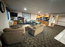 A living room with two sofas, a coffee table, and a dining area with chairs and a table.