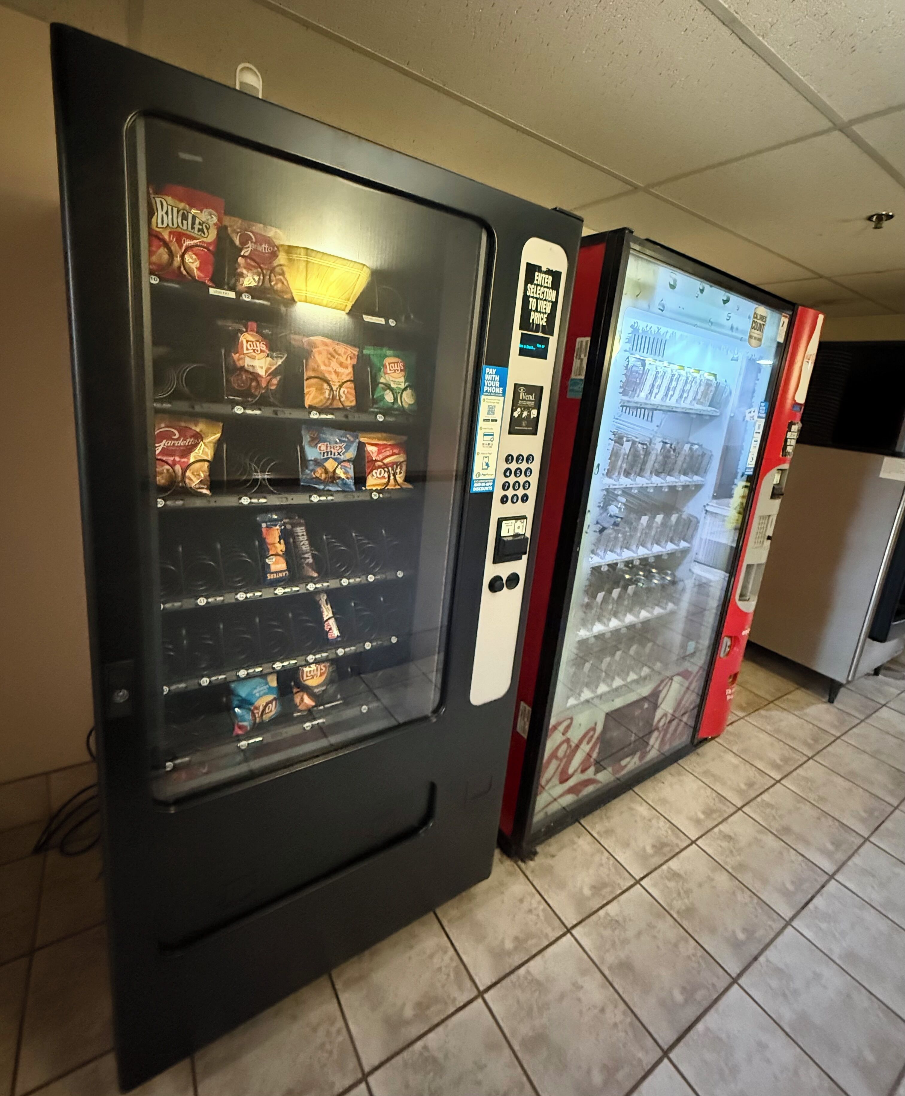 Dos máquinas expendedoras con opciones de comida y una interfaz de pago.
