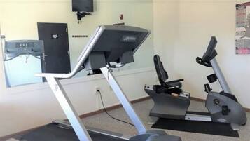 Ein Fitnessraum mit Laufbändern und einer Spiegelwand.