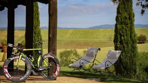 Bicicleta com uma garrafa de água e um par de espreguiçadeiras em ambiente rural.