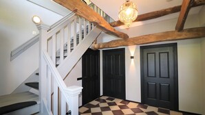 A staircase with white railings and a checkered floor leading to a door. - Dalerveen Apartment With Sauna for 7 (Dalerveen)