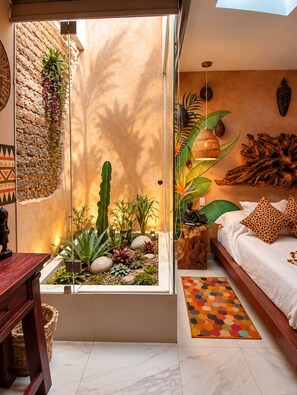 A bedroom with a bed, a small window, a plant, and a decorative wall. - Hotel Boutique Ekléctic (Guadalajara)