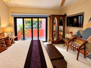 Une chambre d’hôtel avec un lit, une télévision, une armoire en bois et un balcon avec vue.